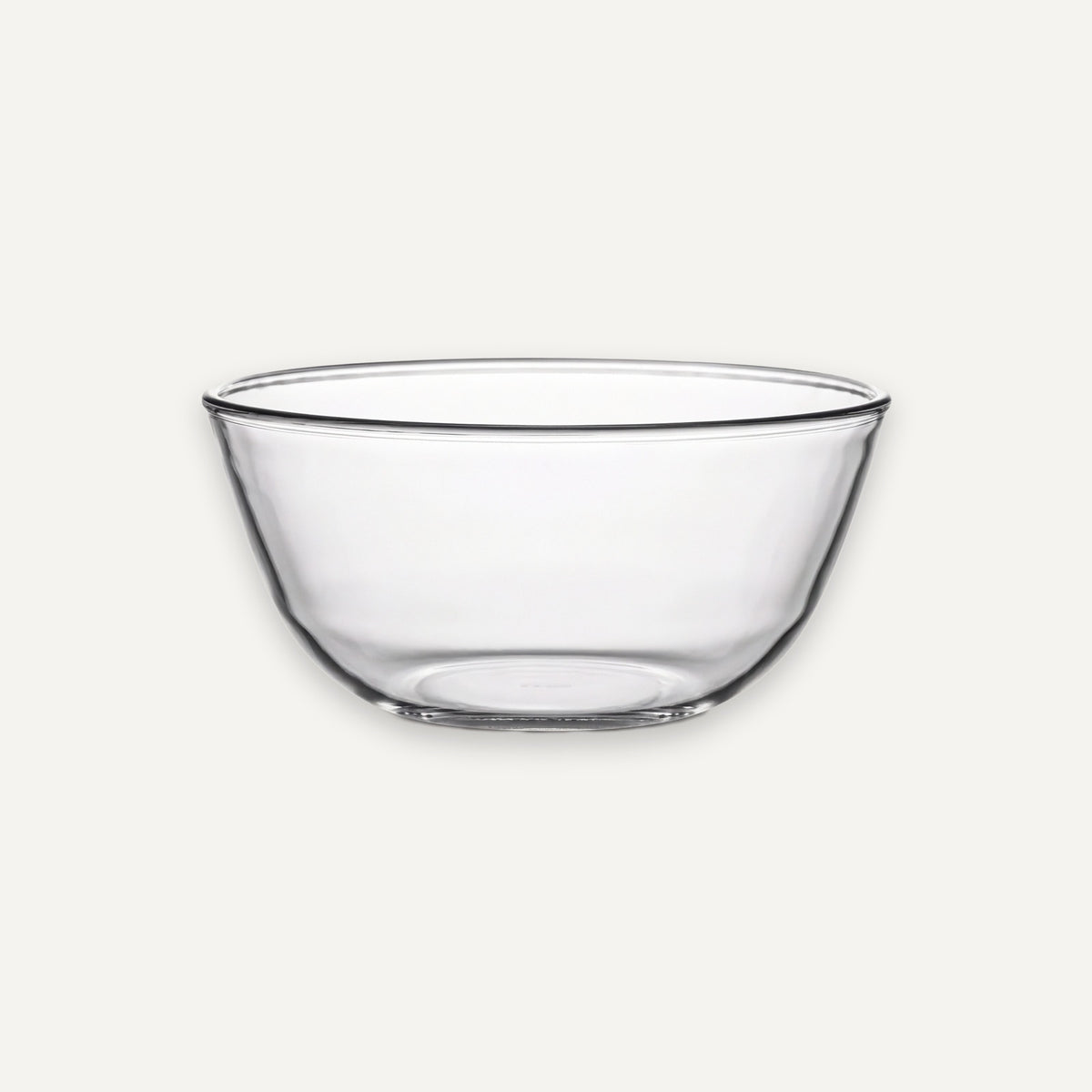 A clear glass mixing bowl with a wide rim and slightly tapered base, shown on a plain light gray background.