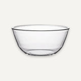 A clear glass bowl with a wide rim and slightly tapered sides, shown against a plain light gray background.