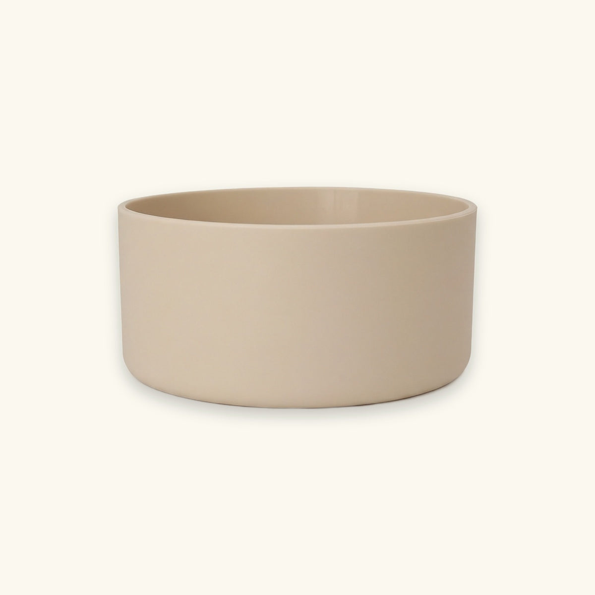 A minimalist, matte ceramic bowl in a light beige color, shown from a front-facing perspective against a solid cream background.