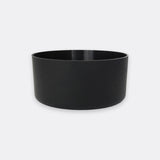 A minimalist black cylindrical planter or bowl with a matte finish, shown against a light gray background.