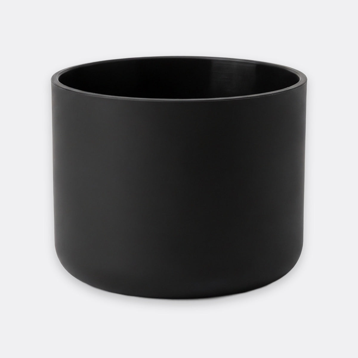 A matte black cylindrical planter or candle holder with a smooth, non-reflective finish, shown against a plain light gray background.