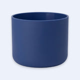 A matte navy blue cylindrical planter pot on a light gray background.