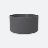A dark gray cylindrical planter or bowl with a matte finish, shown against a light gray background.