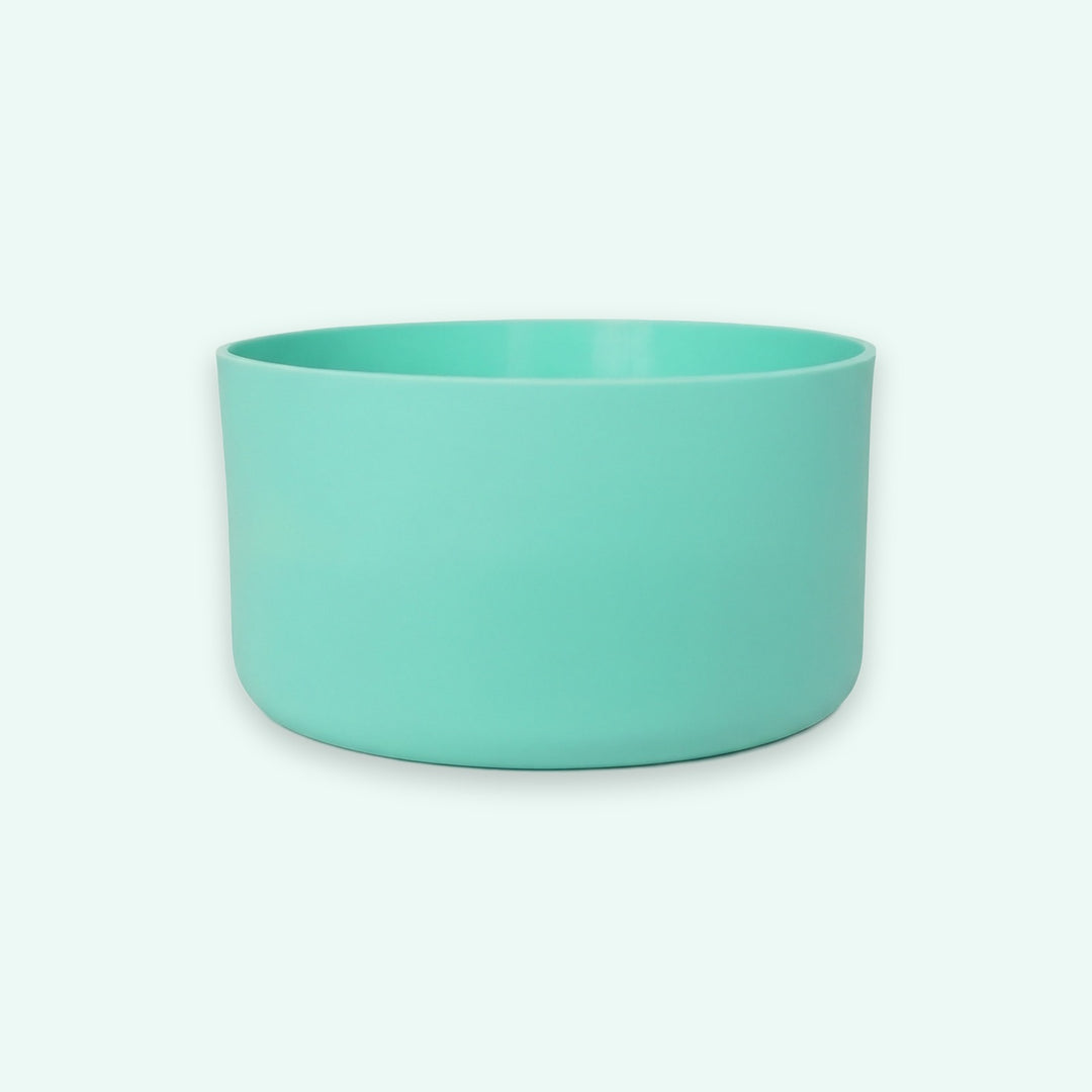 A minimalist, matte-finish round planter or bowl in a vibrant mint green color, centered against a very light off-white background.
