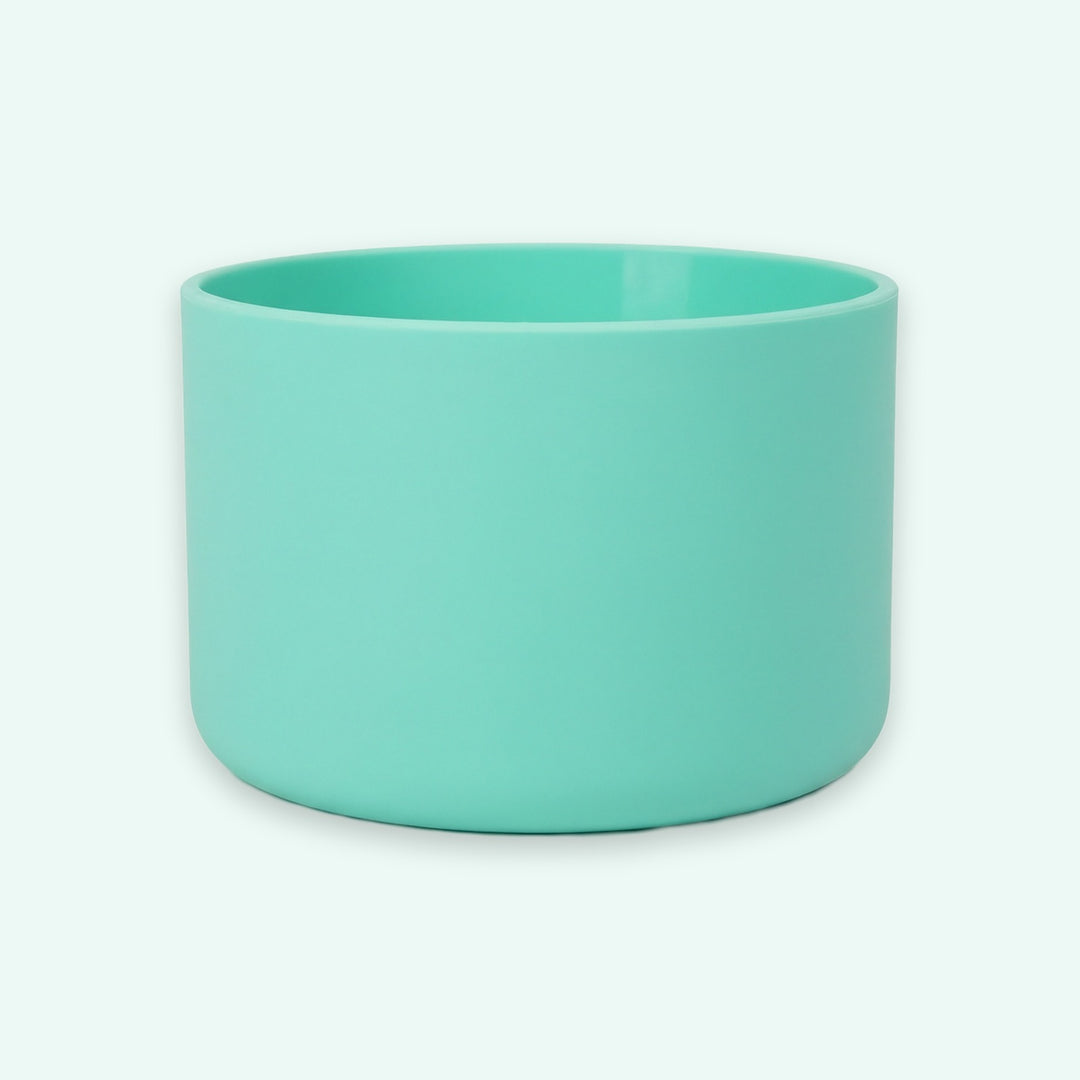 A mint green cylindrical cup or small planter with a matte finish, shown against a solid off-white background.