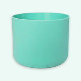 A matte mint green cylindrical planter pot on a clean, very light off-white background.