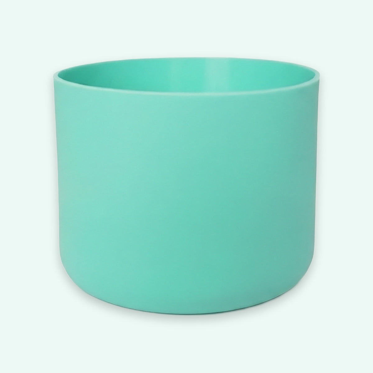 A matte mint green cylindrical planter pot on a clean, very light off-white background.