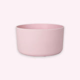 A minimalist, matte light pink cylindrical bowl or planter with a wide rim, shown against a solid pale pink background.