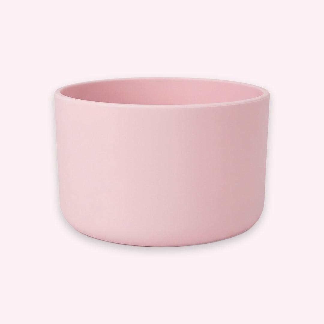A minimalist, matte light pink cylindrical planter or candle holder with a wide rim, shown on a solid pale pink background.