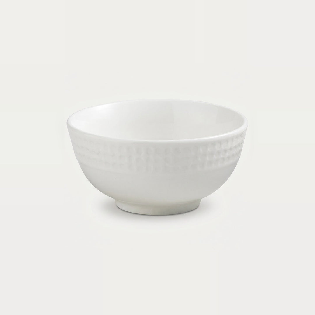 A white ceramic bowl with a textured basketweave pattern on the exterior, shown against a solid off-white background.