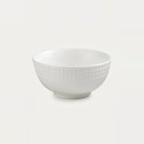 A white ceramic bowl with a textured, dimpled pattern on the exterior, shown against a plain light gray background.
