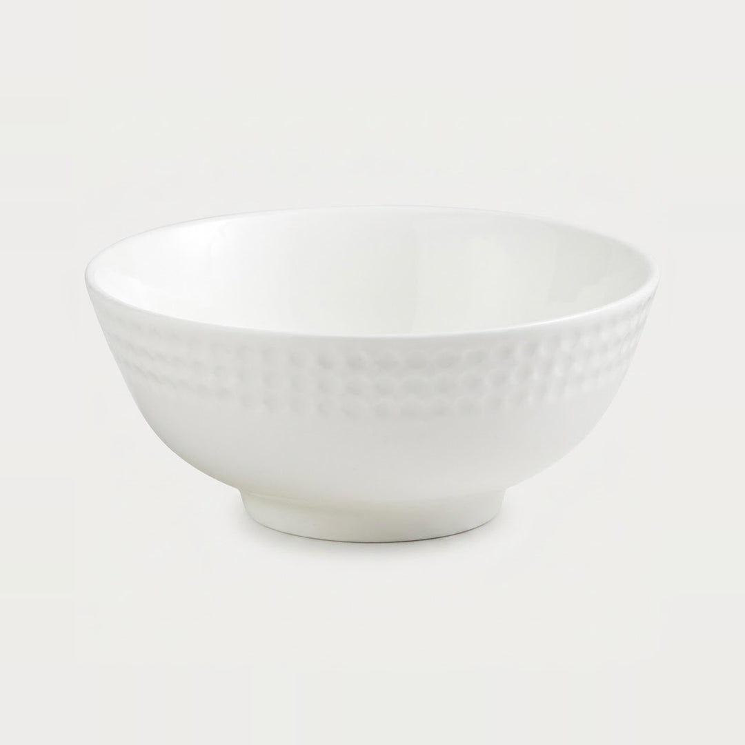 A white ceramic bowl with a textured, dimpled pattern around the outer side, shown against a plain white background.