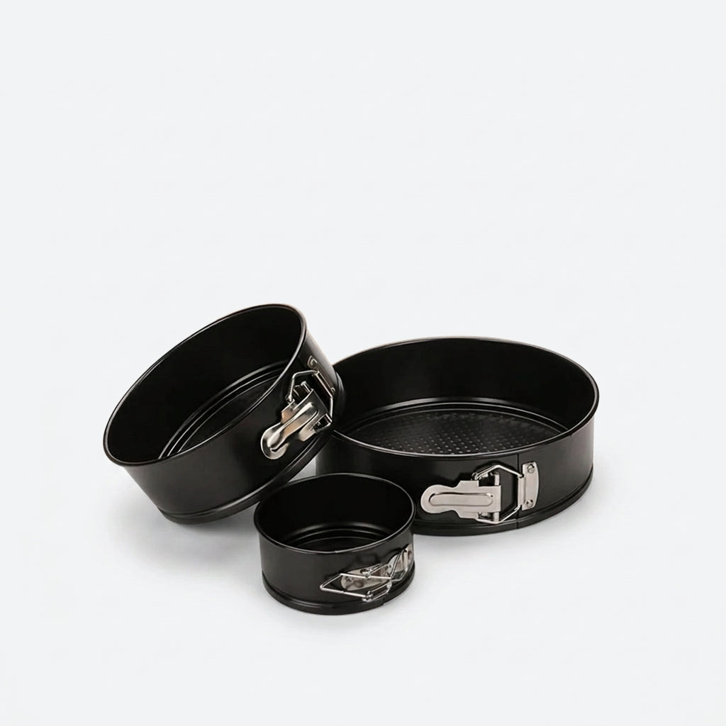 Three-piece black springform cake pan set with silver metal clamps, shown on a light gray background with a small inset image of a decorated two-tier cake.