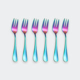 Six iridescent stainless steel forks arranged in a row on a light gray background, featuring a vibrant blue, green, and pink color-shifting finish.