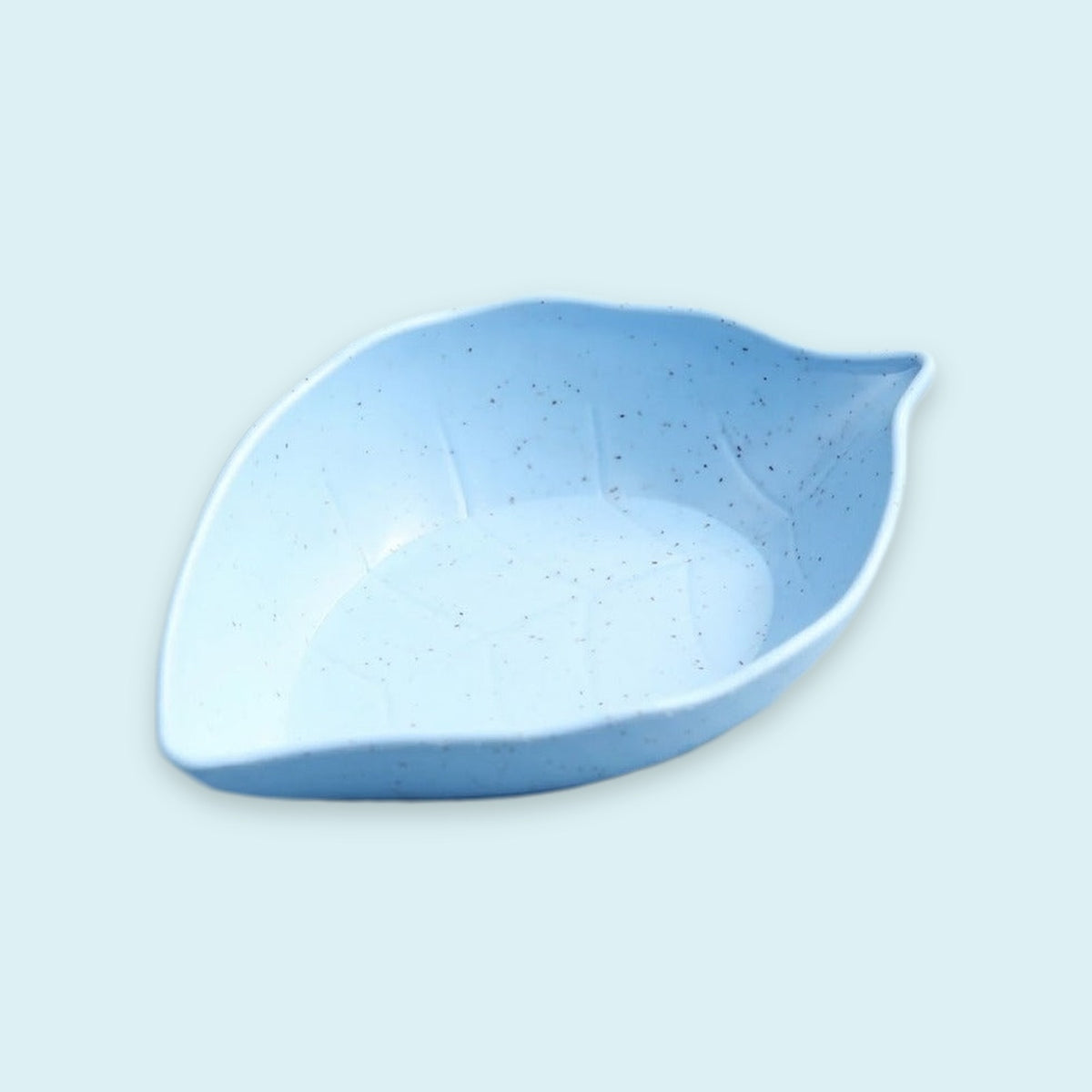Light blue leaf-shaped dish with dark speckles and raised vein details against a pale blue background.