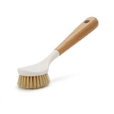 A white-headed dish brush with tan bristles and a wooden handle with a hanging hole stands on a white background.