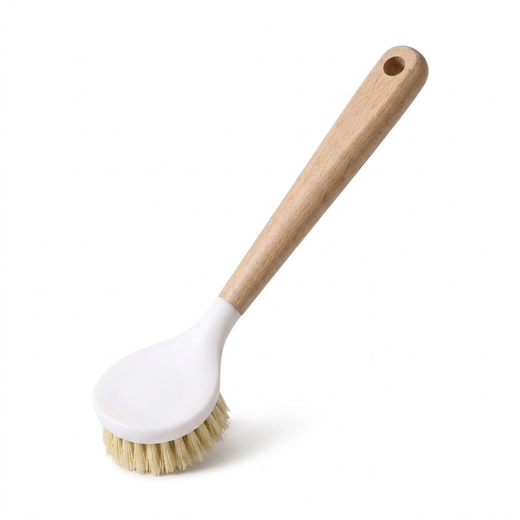 A dish brush with a long wooden handle, white oval head and tan bristles is displayed diagonally against a white background.