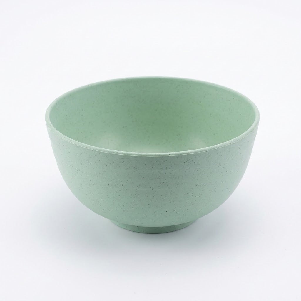 An empty pale green speckled bowl with rounded sides and a circular base sits against a white background.