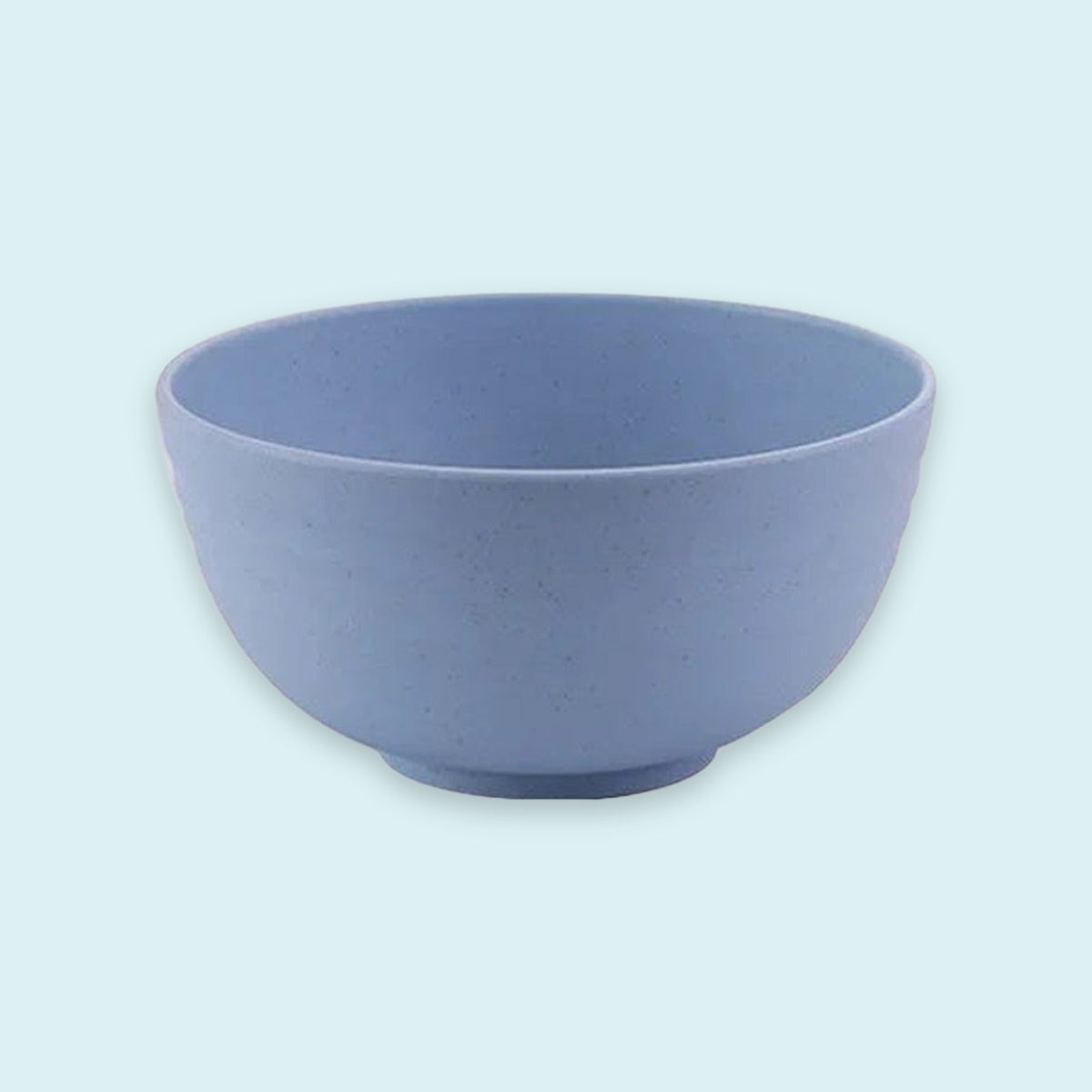 An empty blue speckled bowl with rounded sides and a small circular base sits against a pale blue background.