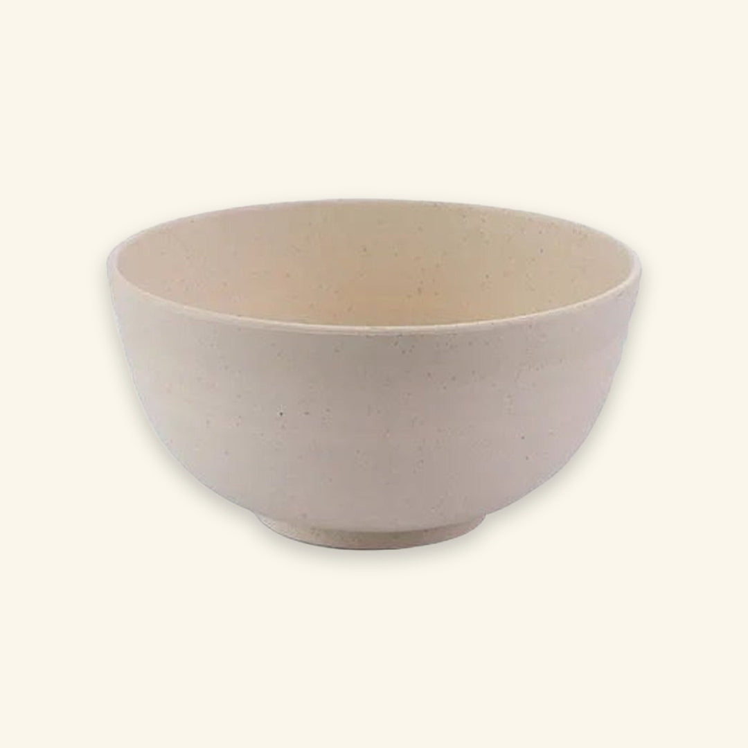 A lightly speckled beige bowl with rounded sides and a raised circular base sits against a cream background.