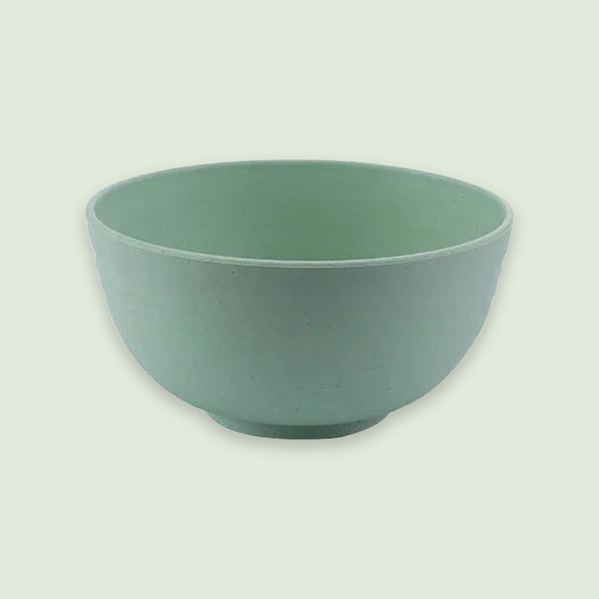 A green bowl with rounded sides and a raised circular base sits against a pale green background.
