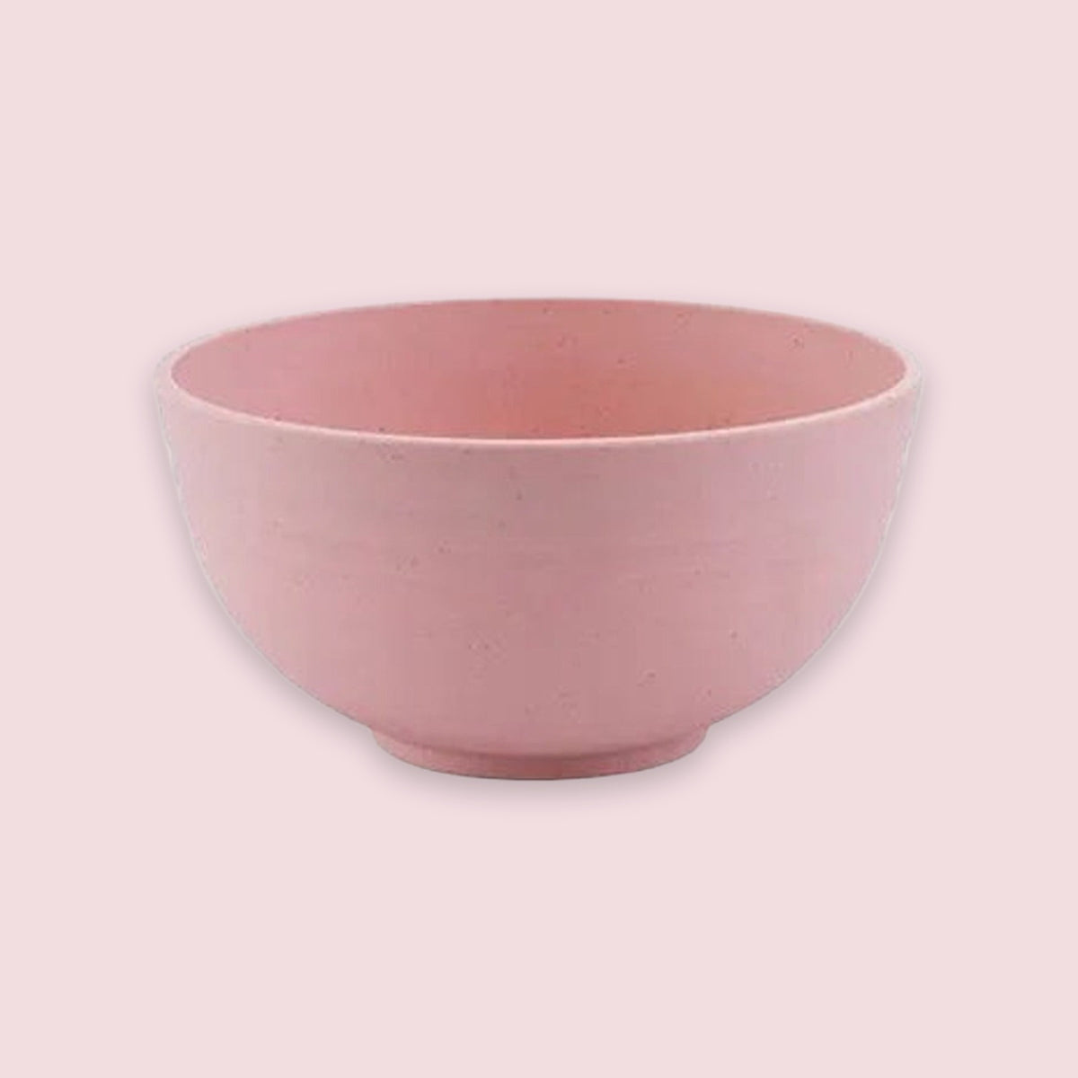 A pink bowl with an open top and rounded sides sits on a circular base against a pale pink background.