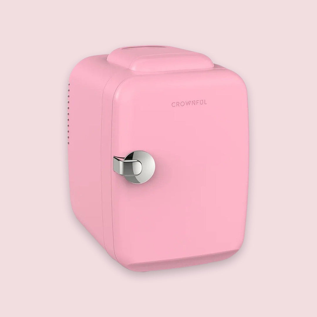 A retro-style pink mini refrigerator with a silver metal handle and the brand name 'CROWNFUL' printed on the front, set against a solid pale pink background.