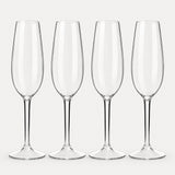 Set of 4 rounded clear Tritan plastic champagne flutes on a light warm grey backdrop