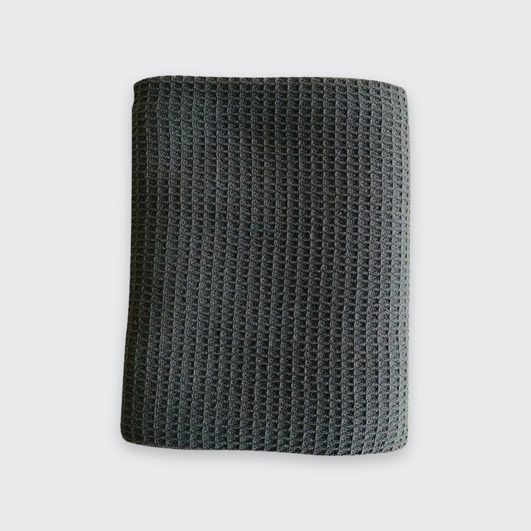 A dark gray waffle-knit fabric sleeve or pouch, shown flat against a light gray background.