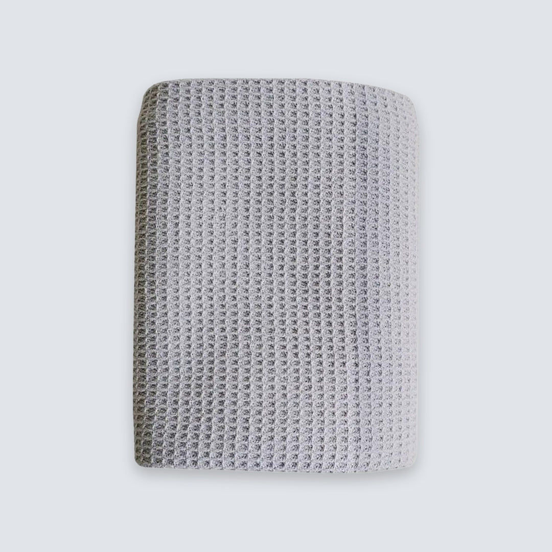 A square gray knit fabric wristband or cuff with a textured waffle pattern, shown against a light gray background.