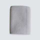A square gray knit fabric wristband or cuff with a textured waffle pattern, shown against a light gray background.