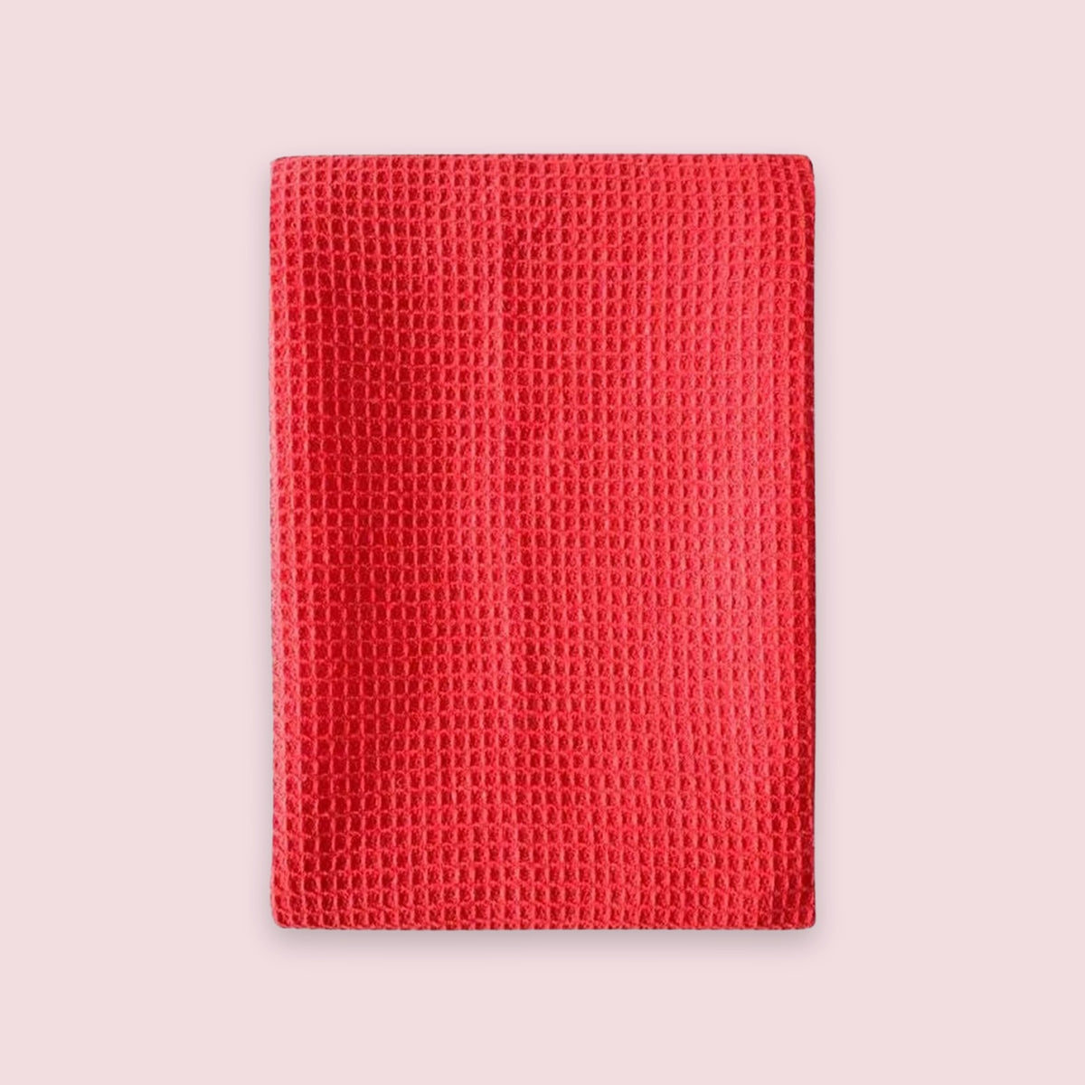 A red textured waffle-weave fabric sleeve or pouch, shown flat against a solid pale pink background.