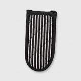 A quilted oven mitt with a black and white vertical stripe pattern, featuring a black stitched border and loop handles, shown on a light gray background.