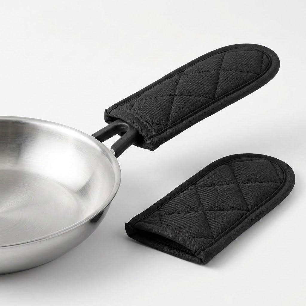 Two black quilted fabric sleeves on a white background, one fitted over a silver pan handle and the other lying beside it.