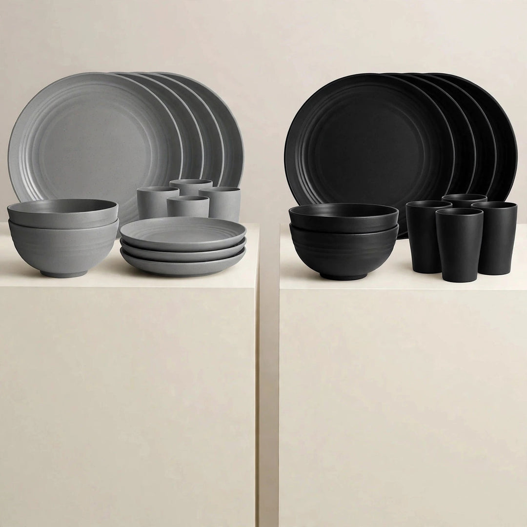 Grey and black dinnerware sets displayed on white pedestals, each with stacked plates, bowls, and cups.