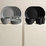 Grey and black dinnerware sets displayed on white pedestals, each with stacked plates, bowls, and cups.