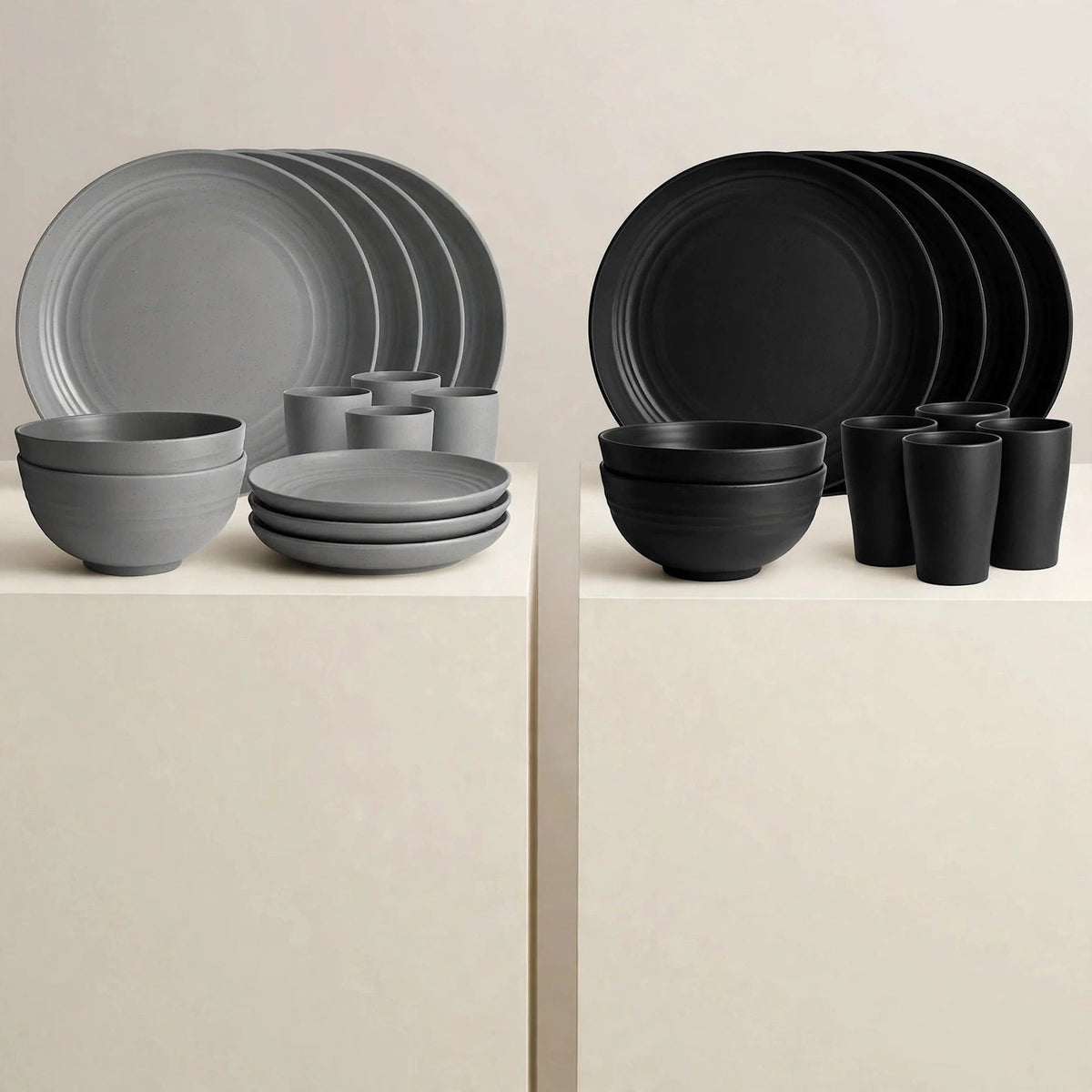 Grey and black dinnerware sets displayed on white pedestals, each with stacked plates, bowls, and cups.