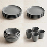 Four stacked groups of grey dinnerware showing plates, bowls, and cups on a beige surface.
