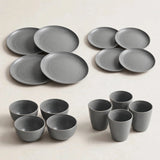 Grey wheat straw dinnerware set with four large plates, four small plates, four bowls, and four cups on a cream background.