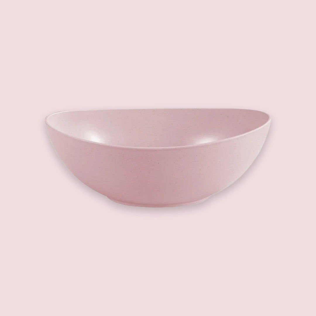 A dusty pink ceramic bowl with a matte, speckled finish, shown from a side angle against a solid, slightly darker pink background.