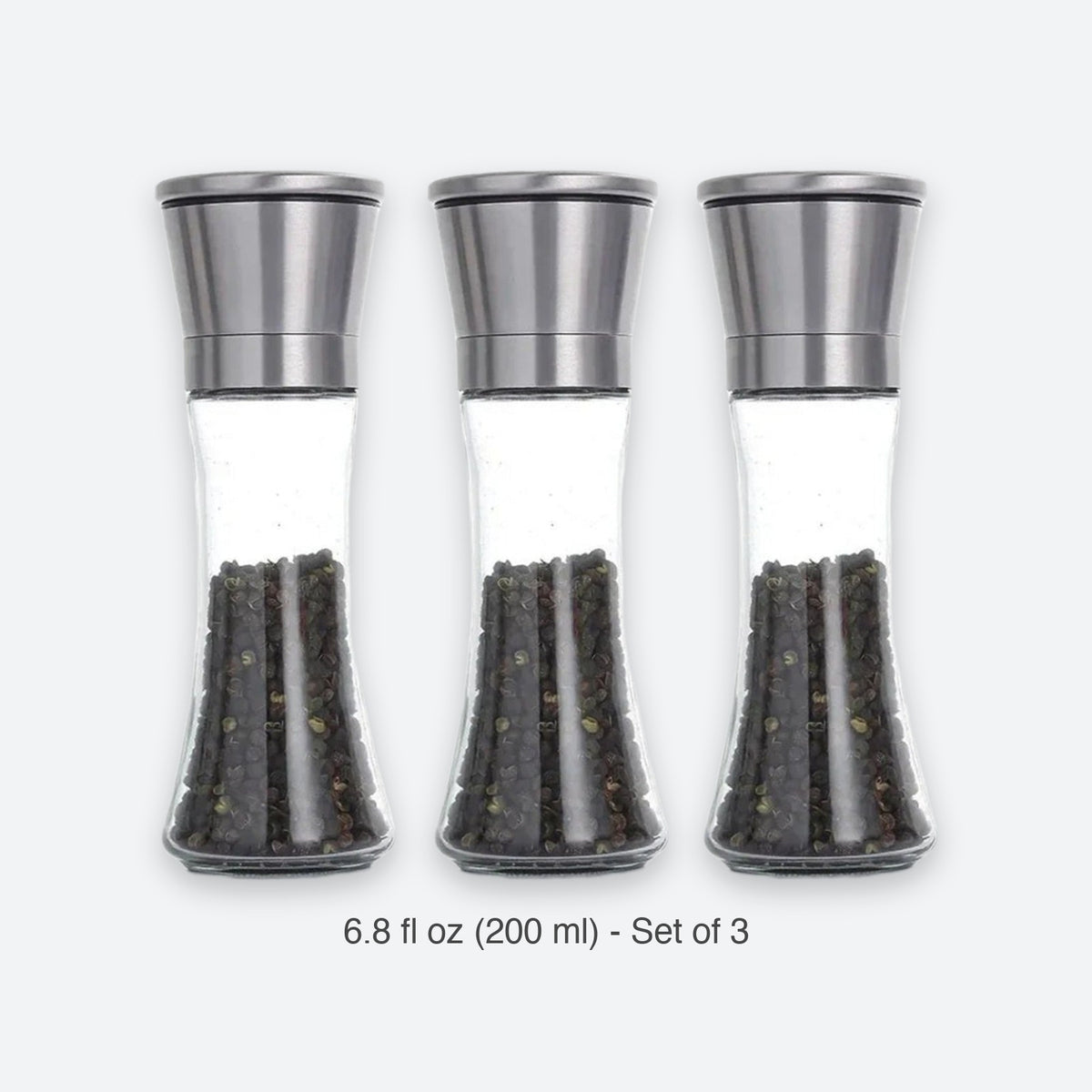 Three clear glass pepper mills with brushed silver metal tops, shown side by side on a light gray background with the text '6.8 fl oz (200 ml) - Set of 3' below.