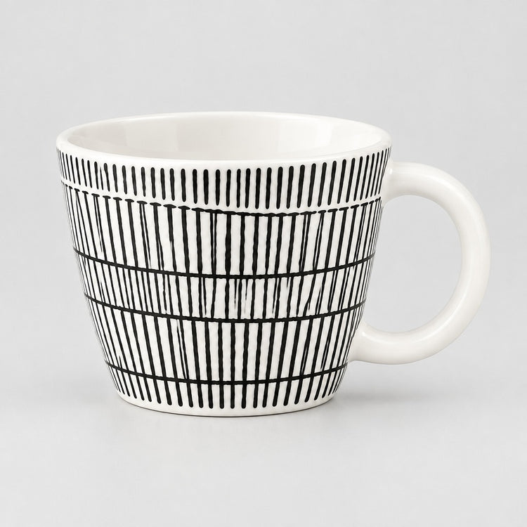 A white ceramic mug with a black hand-drawn vertical stripe pattern, shown against a neutral light gray background.
