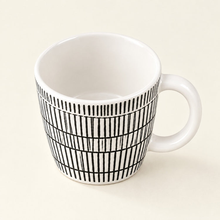 A white ceramic mug with a black vertical stripe grid pattern on the exterior, shown on a light cream background.