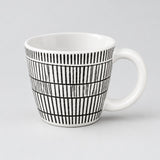 A white ceramic coffee mug with a black hand-drawn vertical stripe pattern, shown on a light gray background.