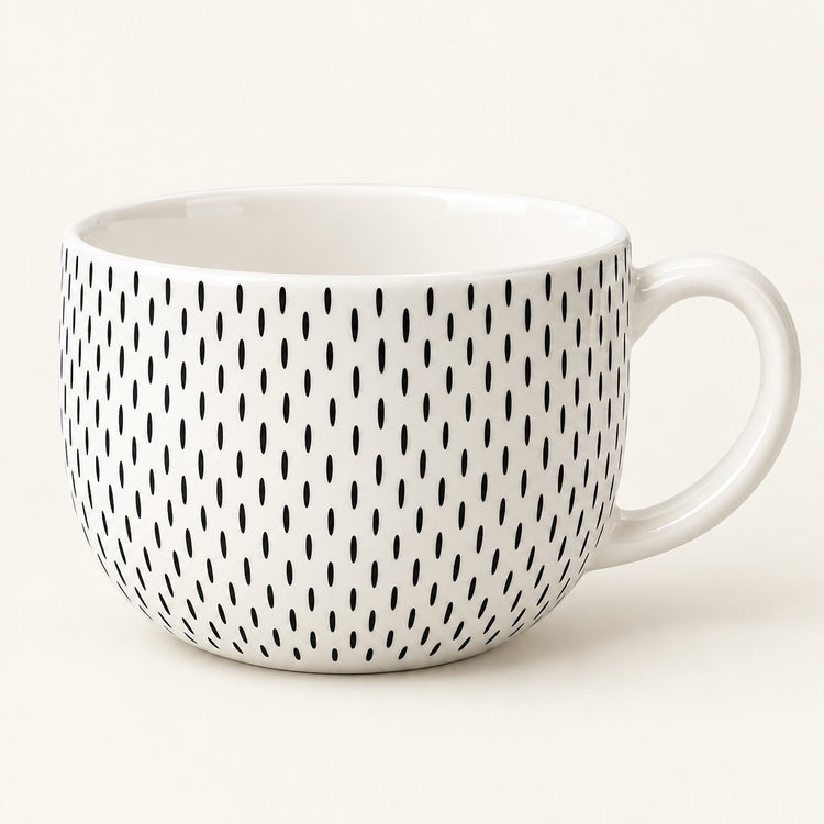 A white ceramic mug with a handle, decorated with a vertical pattern of small black oval marks, shown against a plain off-white background.