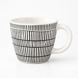 A white ceramic mug with a black hand-drawn vertical stripe pattern, shown on a clean white background.