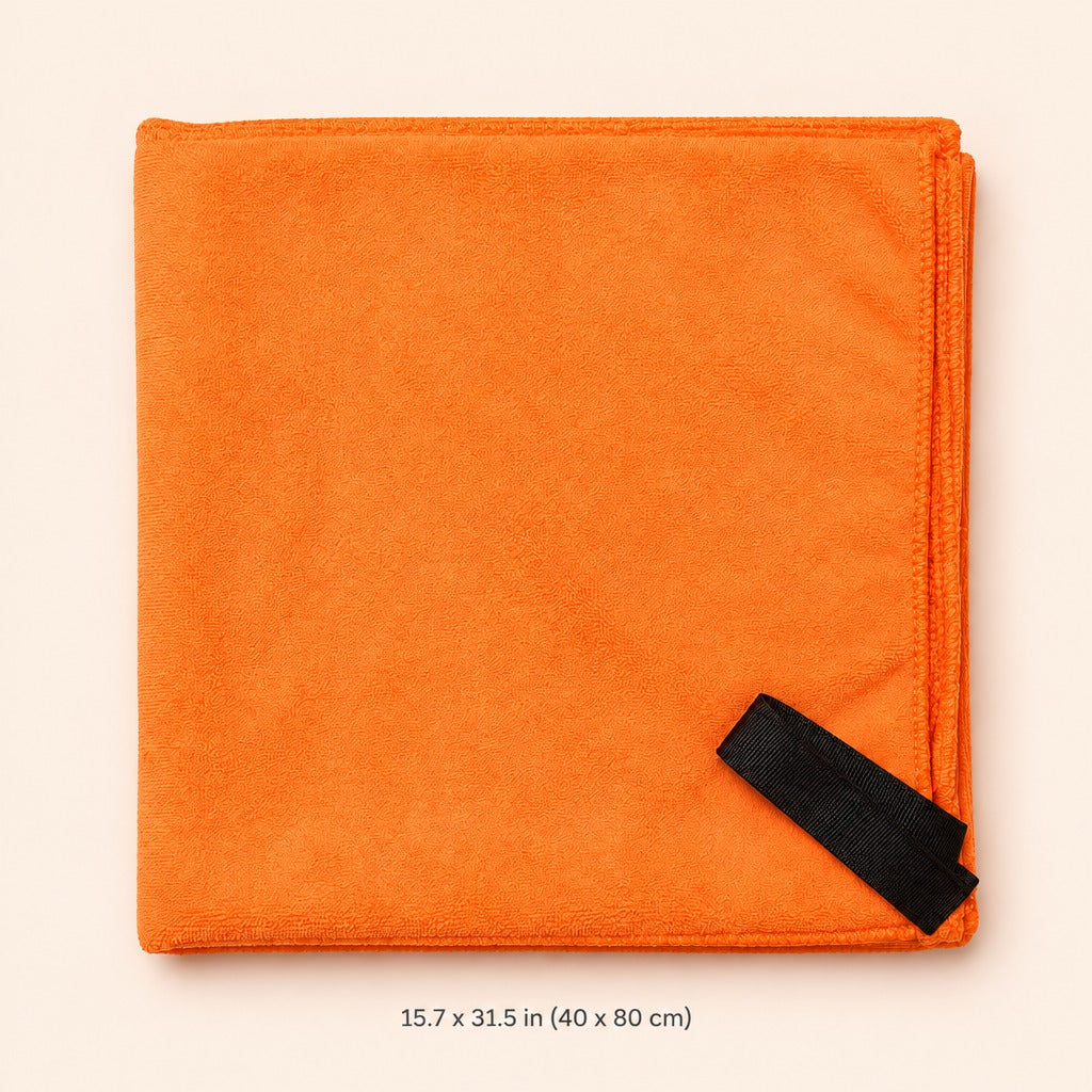 An orange folded microfiber cleaning cloth with a black strap in the bottom right corner, displayed on a light beige background with a size measurement text overlay at the bottom.