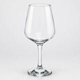 A clear stemmed wine glass with a wide bowl, photographed against a light gray studio background.