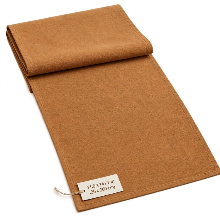 A folded tan fabric runner or table runner with a small white size tag, shown on a plain white background.
