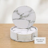A set of round white marble coasters with gray veining, shown with one coaster propped up on top of the others in a cylindrical holder. The set is displayed on a light wood surface against a soft white background, with a text overlay indicating a 3.